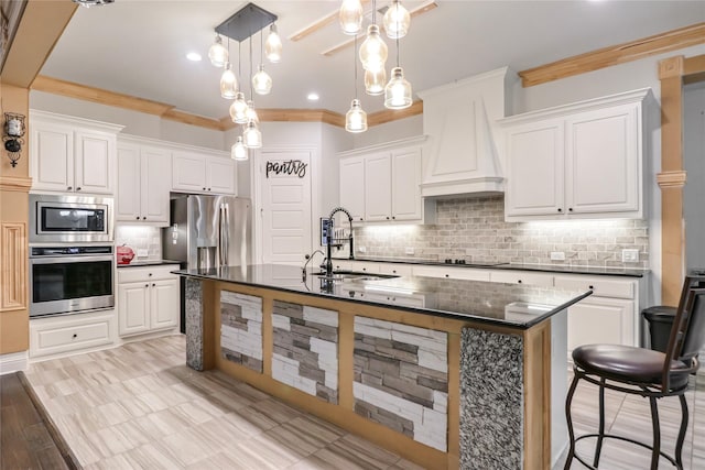 kitchen with white cabinets, custom exhaust hood, sink, and stainless steel appliances