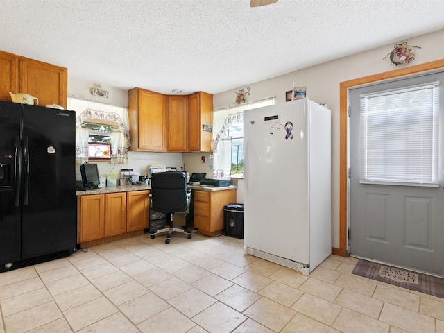 kitchen featuring light tile patterned flooring, white refrigerator, black refrigerator with ice dispenser, and a textured ceiling