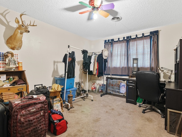 carpeted office featuring a textured ceiling and ceiling fan