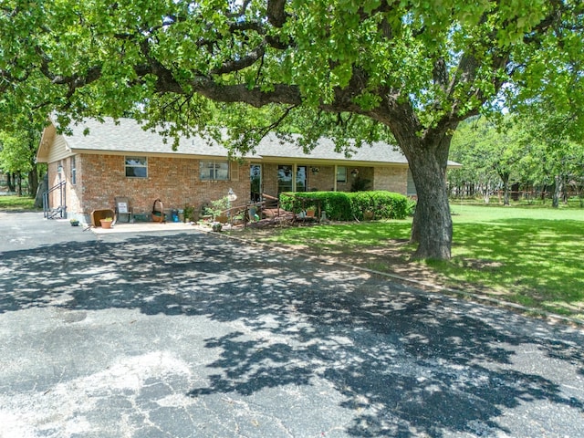 ranch-style home featuring a front yard