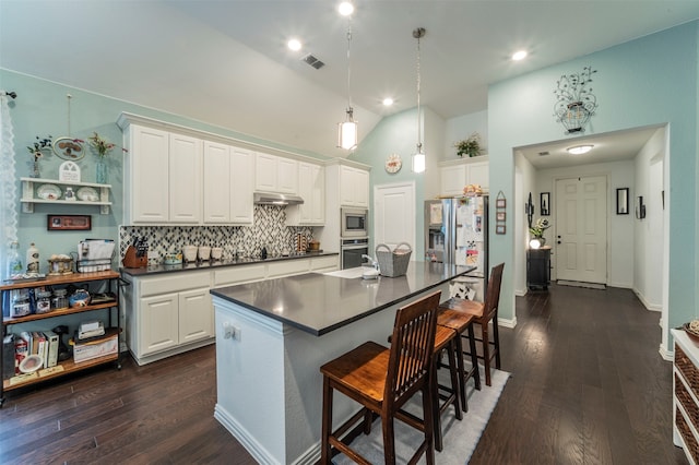 kitchen featuring white cabinetry, tasteful backsplash, dark hardwood / wood-style flooring, appliances with stainless steel finishes, and a center island with sink