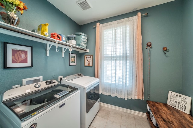 laundry area with light tile patterned flooring and washing machine and clothes dryer