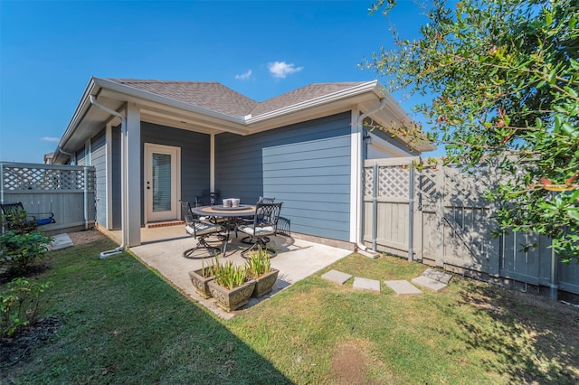 rear view of house featuring a patio area and a yard