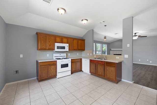 kitchen featuring lofted ceiling, sink, white appliances, light tile patterned floors, and hanging light fixtures