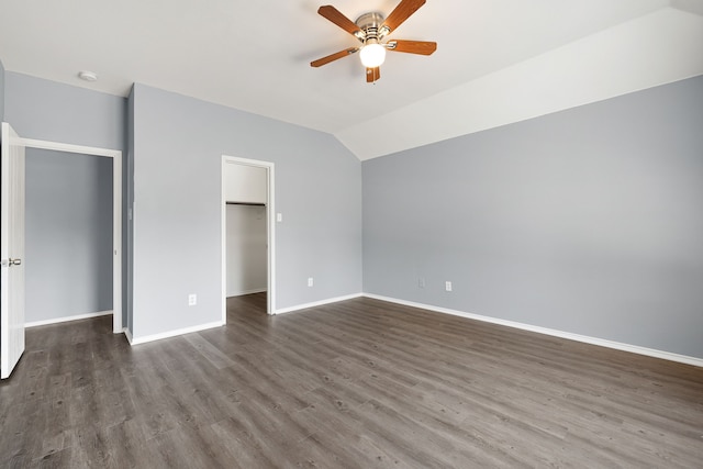 unfurnished bedroom featuring ceiling fan, dark hardwood / wood-style flooring, a spacious closet, vaulted ceiling, and a closet