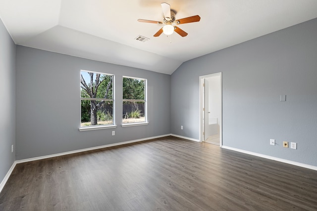 spare room with dark hardwood / wood-style flooring, vaulted ceiling, and ceiling fan