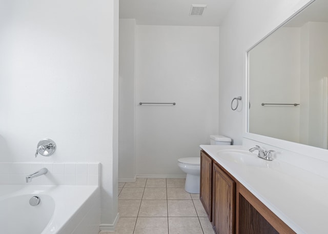 bathroom featuring tiled tub, vanity, tile patterned floors, and toilet