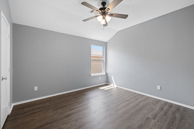 spare room with dark hardwood / wood-style flooring, vaulted ceiling, and ceiling fan