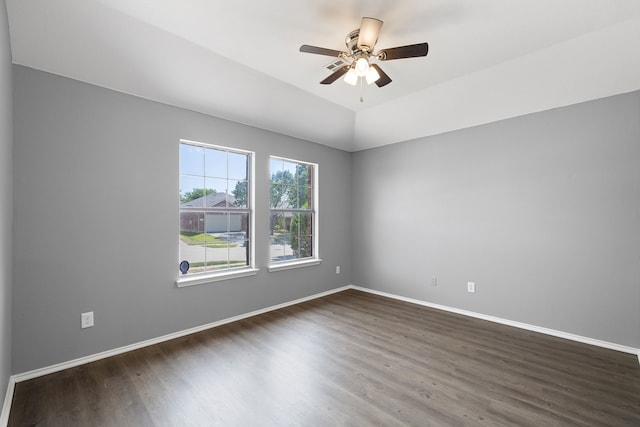 empty room with ceiling fan, dark hardwood / wood-style flooring, and vaulted ceiling