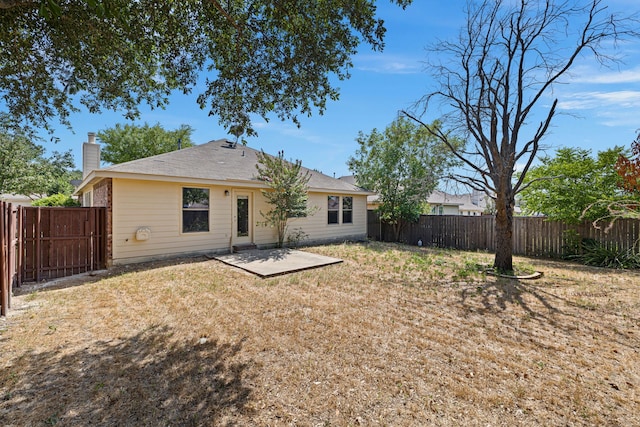 rear view of house featuring a lawn and a patio area