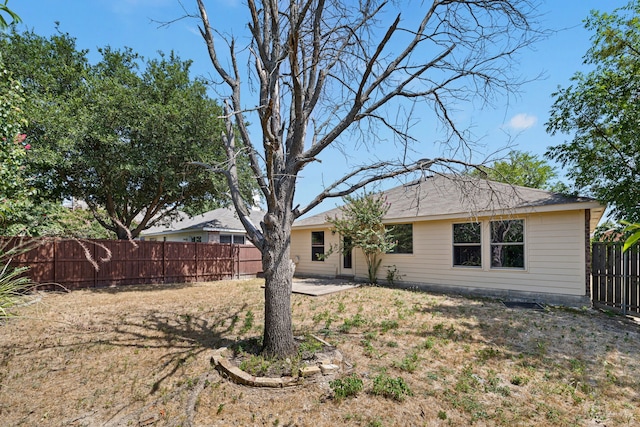 rear view of property featuring a yard and a patio