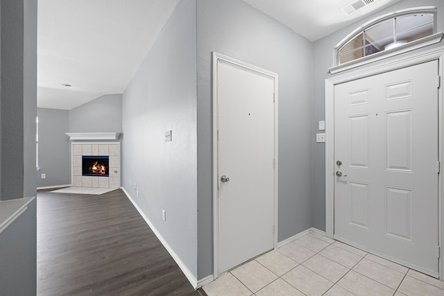 entrance foyer featuring a tile fireplace and light wood-type flooring