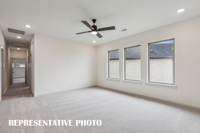 carpeted spare room with ceiling fan