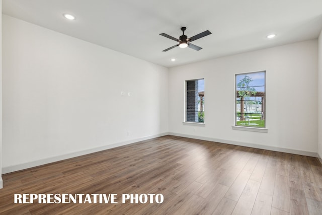 empty room with hardwood / wood-style floors and ceiling fan