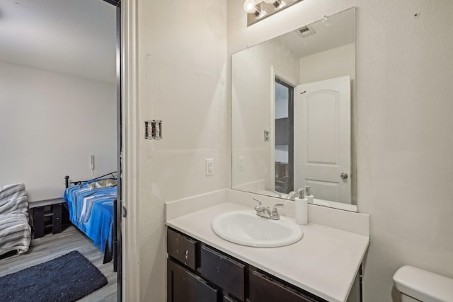 bathroom with wood-type flooring, toilet, and vanity