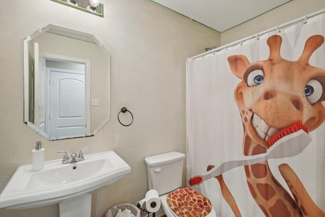 bathroom featuring sink, toilet, and walk in shower