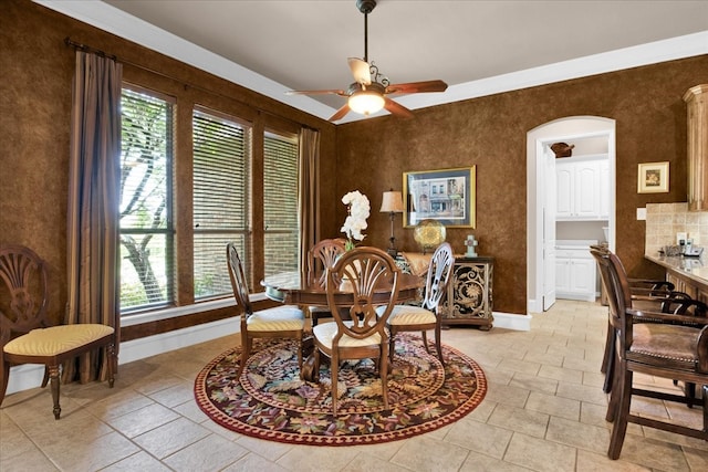 dining space featuring ceiling fan and ornamental molding