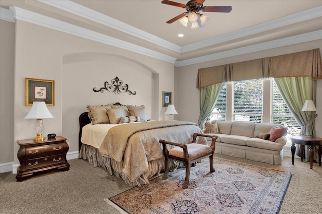 carpeted bedroom with ceiling fan, crown molding, and a tray ceiling