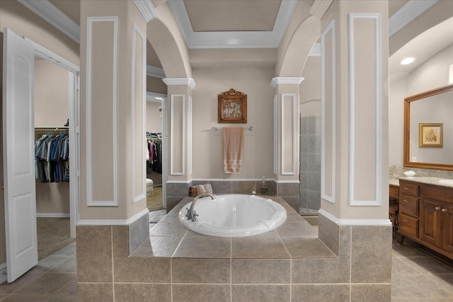 bathroom with vanity, tiled tub, ornamental molding, and ornate columns