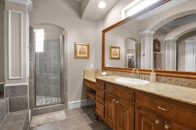 bathroom with walk in shower, vanity, and ornate columns