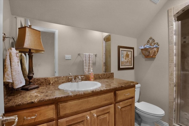 bathroom with toilet, a shower with door, vaulted ceiling, and vanity