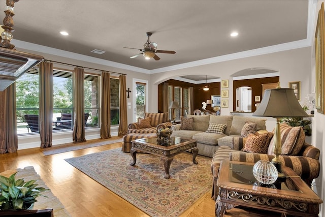 living room featuring ceiling fan, crown molding, and light wood-type flooring