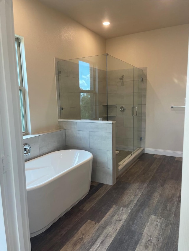 bathroom with hardwood / wood-style floors and independent shower and bath