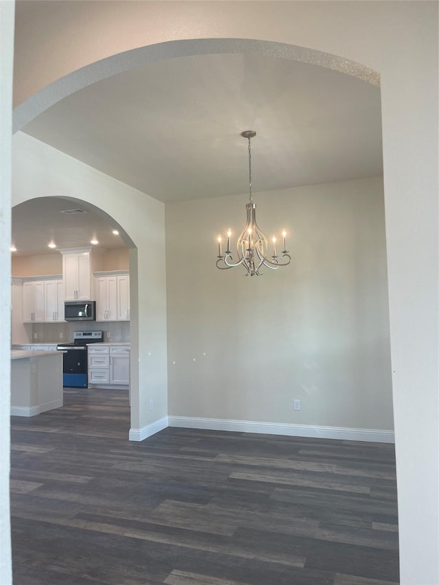 kitchen featuring white cabinetry, decorative light fixtures, a chandelier, appliances with stainless steel finishes, and dark hardwood / wood-style floors