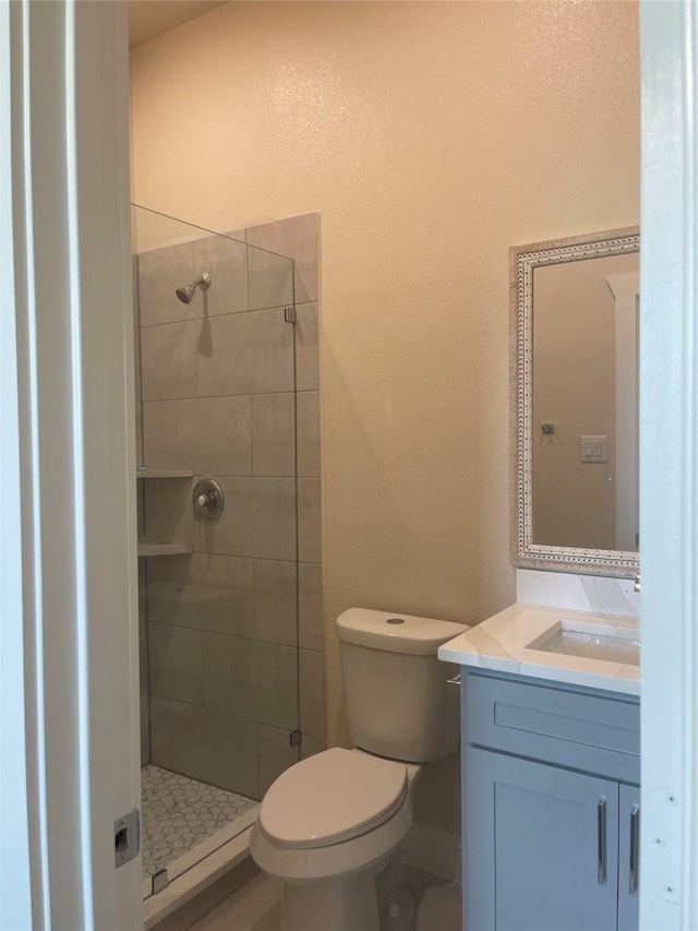 bathroom with walk in shower, vanity, and toilet