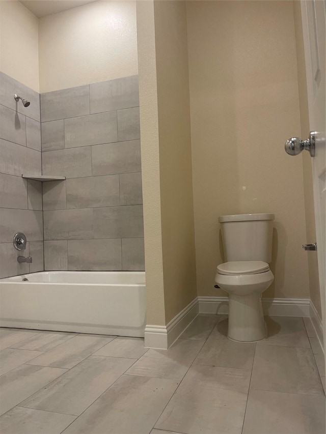 bathroom with tiled shower / bath combo and toilet