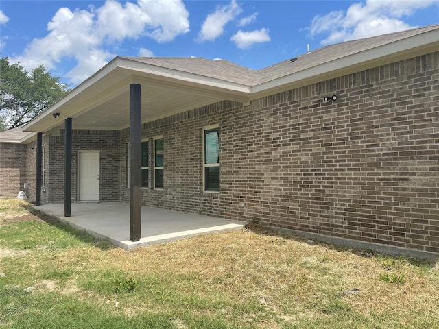 rear view of house with a yard and a patio