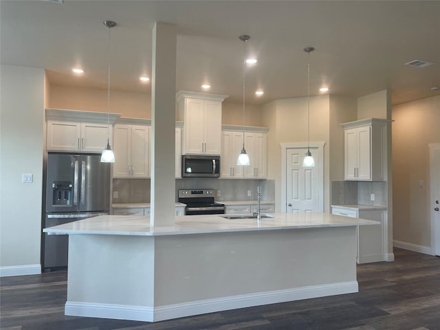 kitchen with stainless steel appliances, sink, a center island with sink, and white cabinets