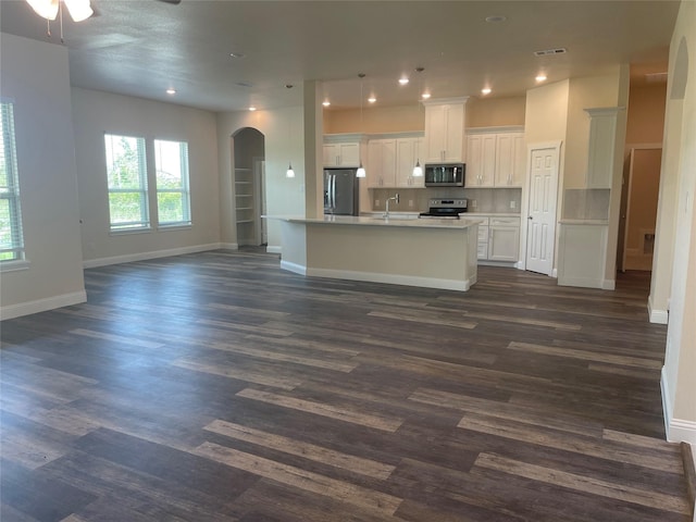 kitchen featuring stainless steel appliances, a kitchen island with sink, white cabinets, and dark hardwood / wood-style flooring