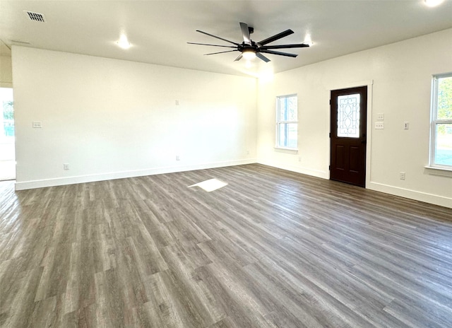 unfurnished living room featuring ceiling fan and dark wood-type flooring