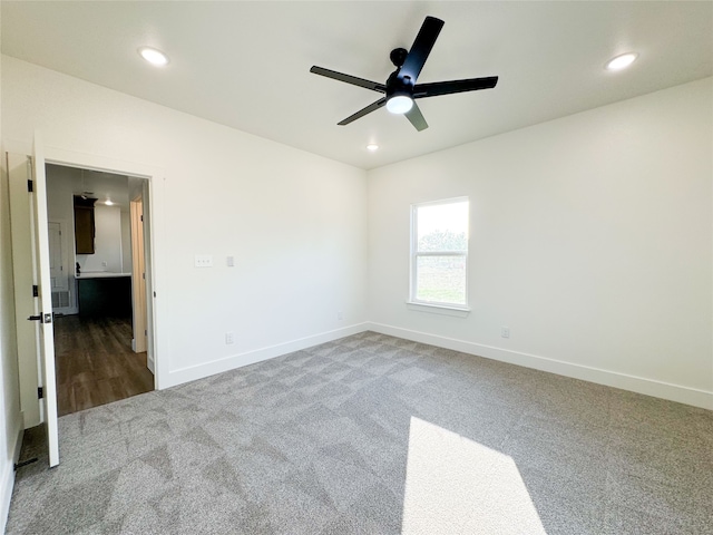 unfurnished room with ceiling fan and carpet