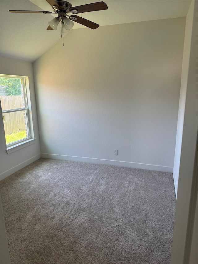 carpeted spare room featuring ceiling fan and vaulted ceiling