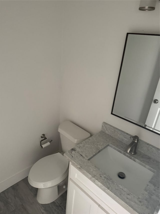 bathroom featuring vanity, toilet, and hardwood / wood-style floors