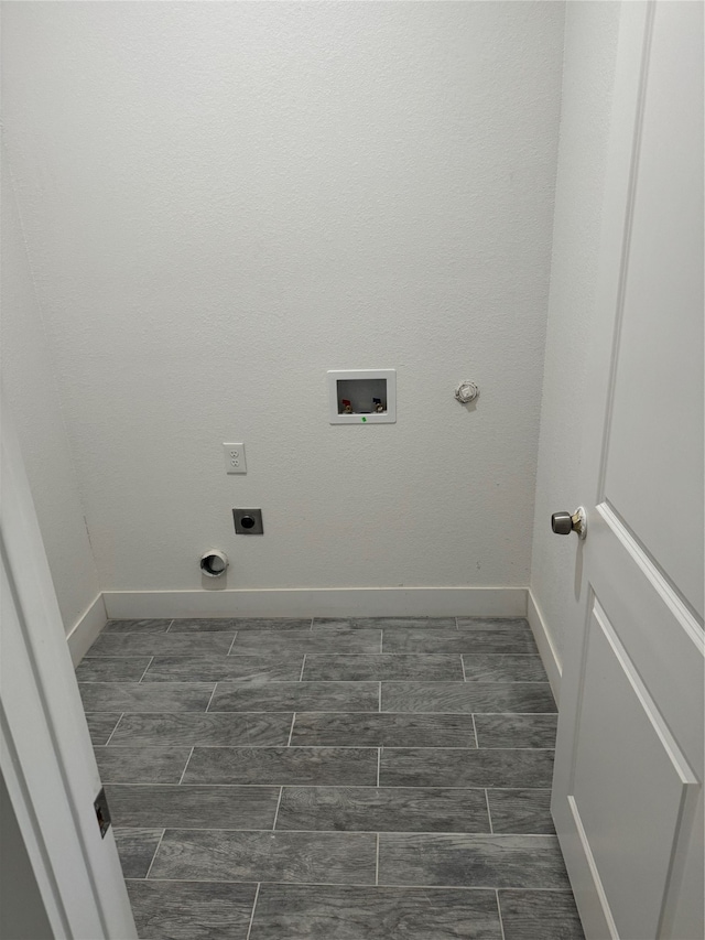 laundry area featuring hookup for a washing machine, electric dryer hookup, and dark tile patterned flooring