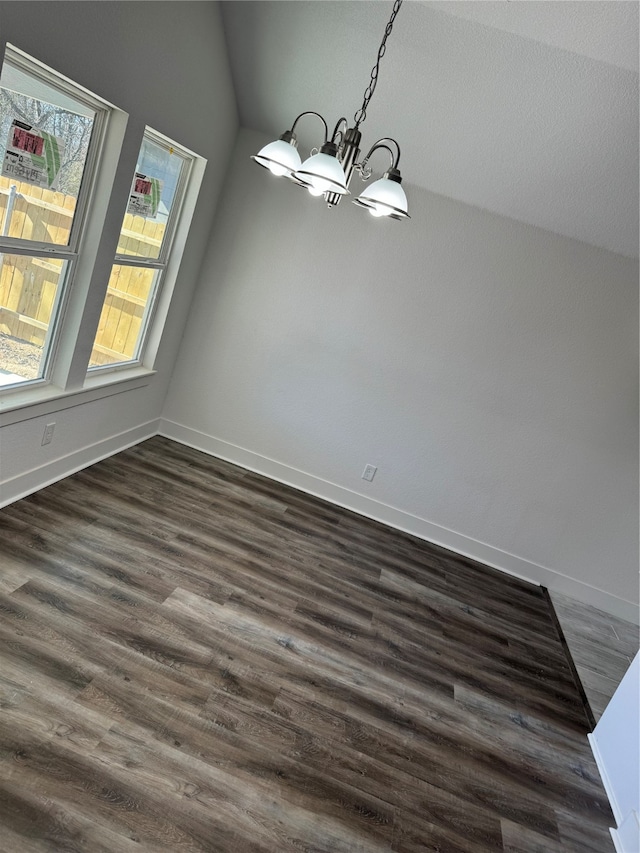 bonus room featuring a high ceiling, dark wood-type flooring, a textured ceiling, and a notable chandelier