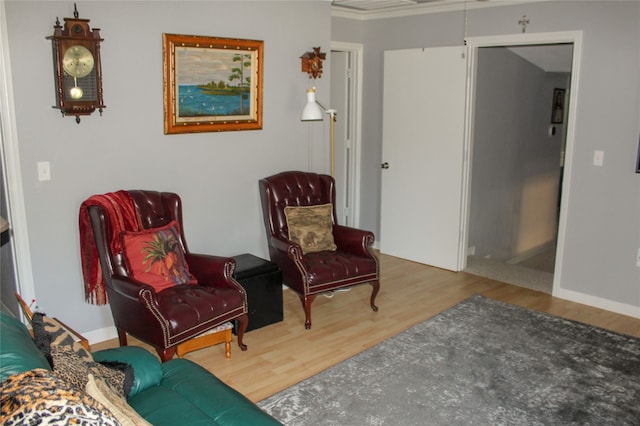 living area featuring wood-type flooring and crown molding