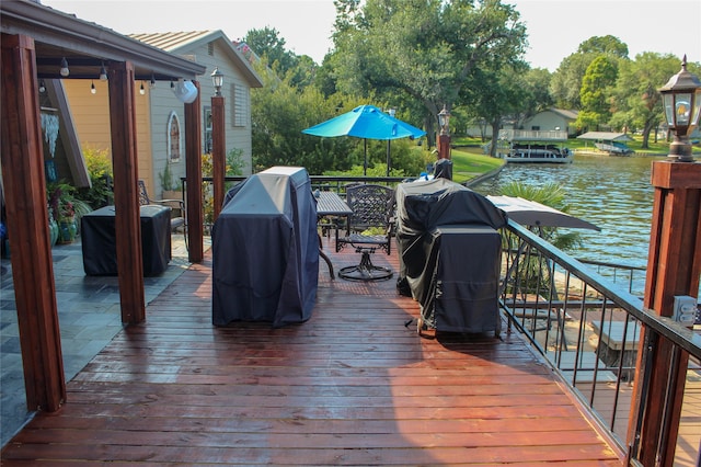 wooden terrace with a grill and a water view