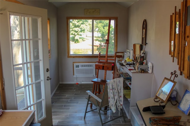 dining space with vaulted ceiling, a wall unit AC, and dark wood-type flooring