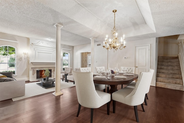 dining room featuring a notable chandelier, dark hardwood / wood-style floors, a wealth of natural light, and a raised ceiling