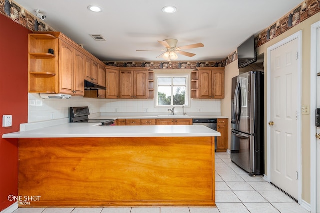 kitchen with stainless steel appliances, tasteful backsplash, sink, and kitchen peninsula