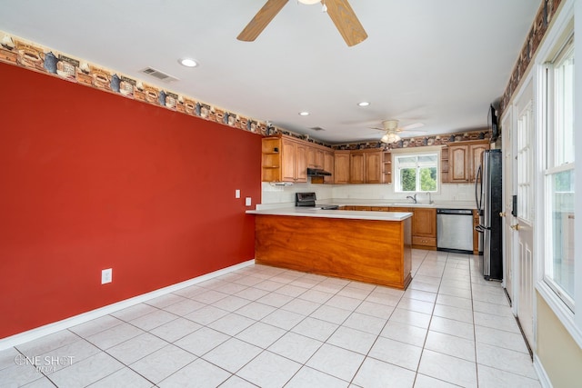 kitchen with sink, appliances with stainless steel finishes, light tile patterned flooring, decorative backsplash, and kitchen peninsula