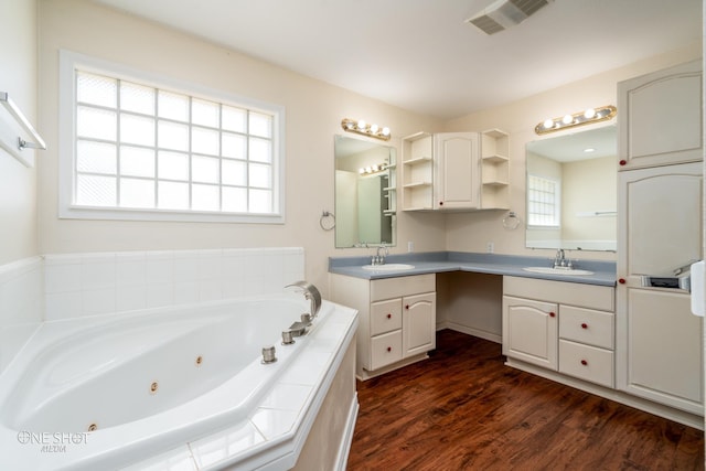 bathroom featuring vanity, hardwood / wood-style floors, and tiled bath