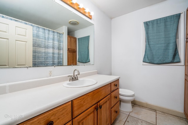 bathroom with tile patterned flooring, vanity, and toilet