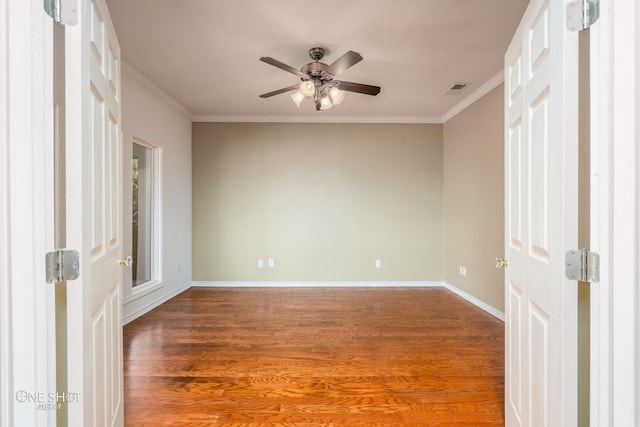 empty room with wood-type flooring, ornamental molding, and ceiling fan