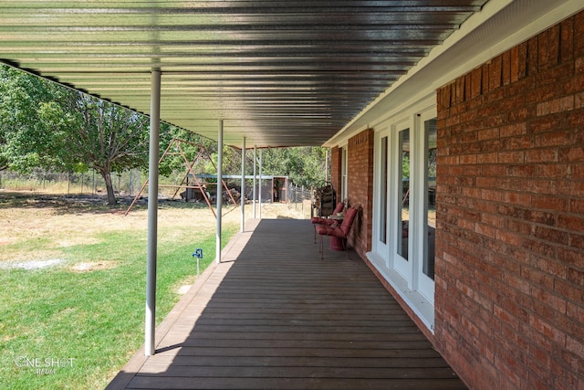 wooden terrace featuring a yard