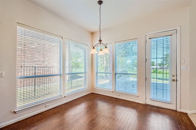 unfurnished dining area with an inviting chandelier, dark hardwood / wood-style floors, and plenty of natural light